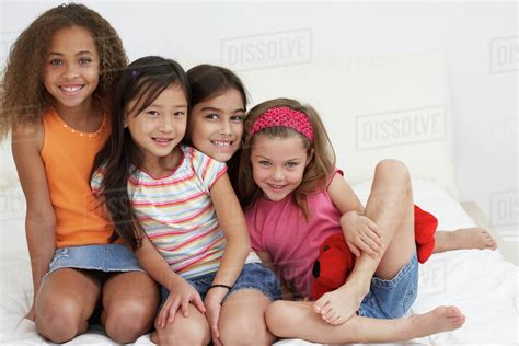 Group of young girls hugging and smiling - Stock Photo - Dissolve