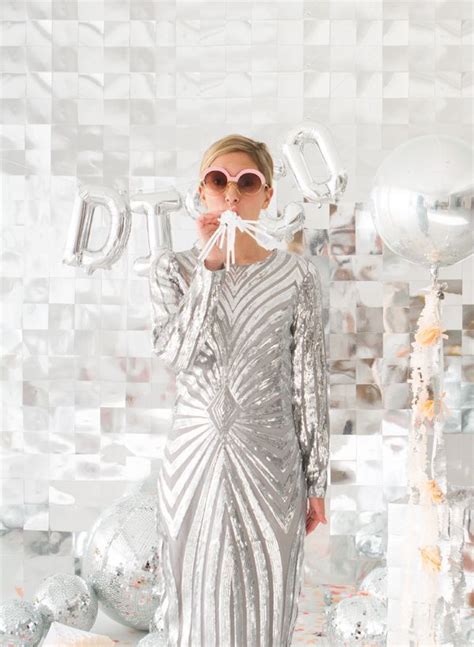 A Woman Standing In Front Of Balloons And Streamers With Her Mouth Open