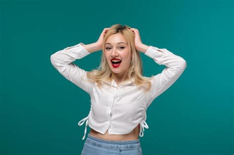 Jolie fille jeune jolie fille blonde dans une chemise blanche tenant la tête très excitée