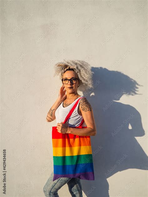 Mujer Joven Con Tatuajes Sujetando Un Bolso Con La Bandera Del Orgullo Gay Stock Photo Adobe Stock