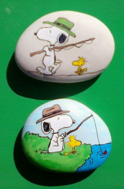 Two Rocks With Cartoon Characters Painted On Them One Is Holding A