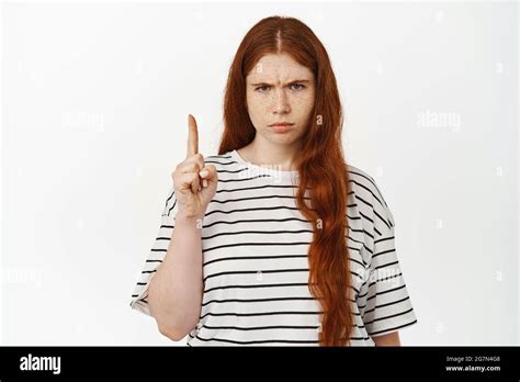 Angry And Displeased Redhead Girl Pointing Finger Up Judgemental Frowning With Dislike