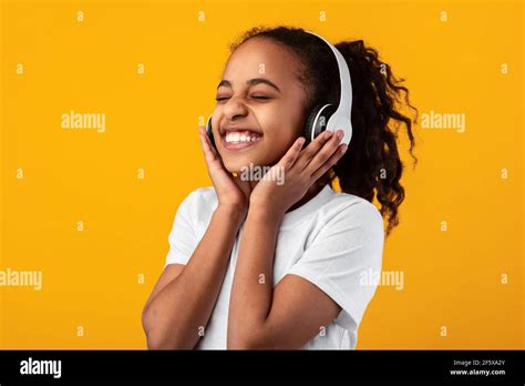 Smiling Young Black Girl Listening To Music In Headset Stock Photo - Alamy