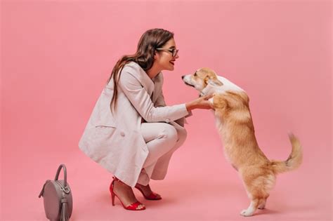 Mulher De Terno Bege Brinca O Cachorro No Fundo Rosa Linda Garota