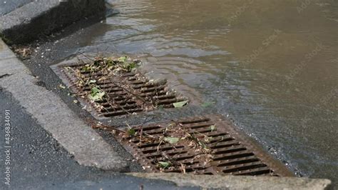 Water Enters A Storm Sewer Clogged With Branches After Heavy Rain