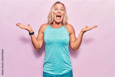 Middle Age Caucasian Blonde Woman Wearing Sports Clothes Over Pink