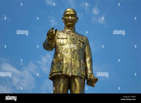 A standing, pointing, shiny gold statue of Chinese leader Chiang Kai ...