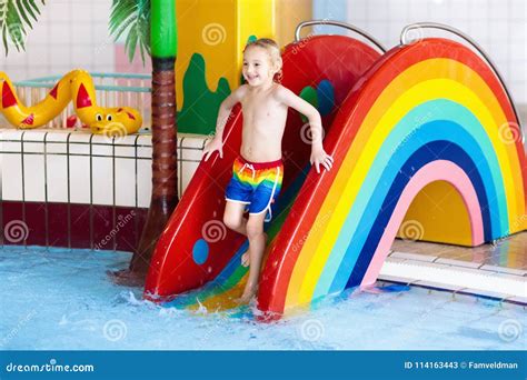 Child on Swimming Pool Slide. Kids Swim. Water Fun Stock Image - Image ...