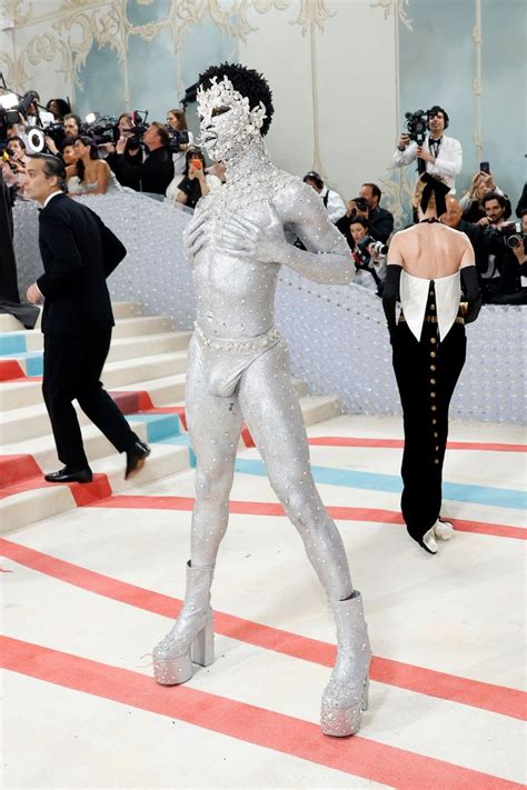 A Man In Silver Suit Standing On Top Of A Red And White Striped Floor