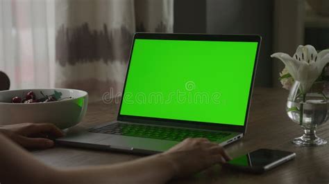 Laptop With Green Screen Pivoting Around Unrecognisable Woman Watching