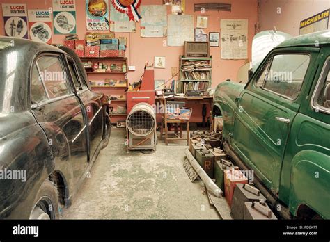 Two Classic Cars In An Old Style Garage In For Servicing And Repair