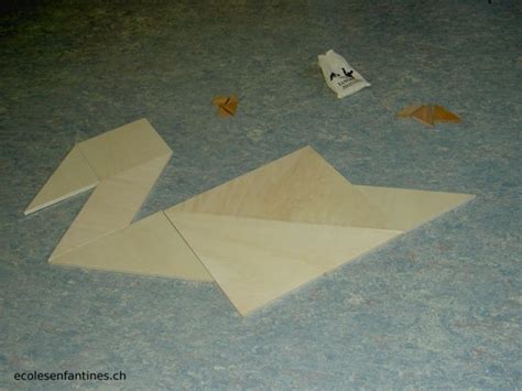 An Origami Swan Is Laying On The Floor Next To Some Pieces Of Paper