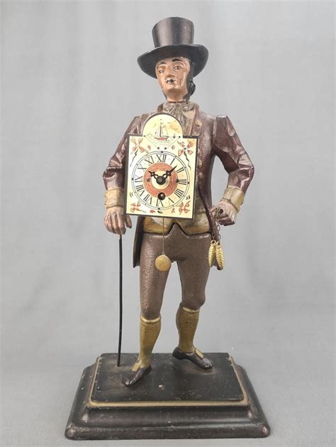 At Auction: Clock man / Black Forest clock man, 20th century, each wearing a shield clo