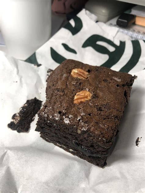 A Piece Of Brownie Sitting On Top Of A White Napkin Next To A Cup