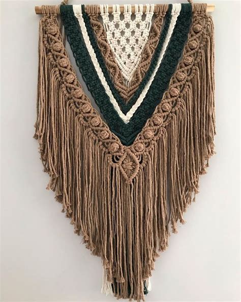 A Wall Hanging Made Out Of Crochet And Yarn With Fringes On It