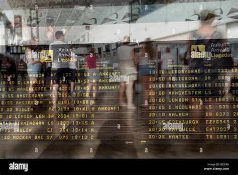 Double exposure image at airport with arrivals board and people waiting ...