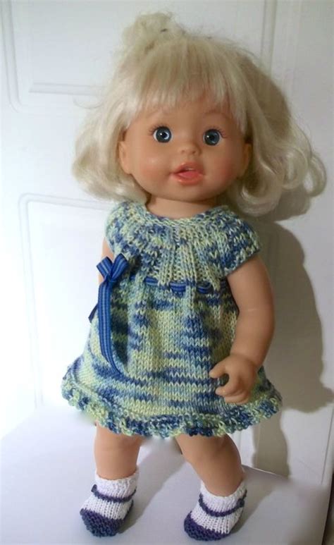 A Doll With Blonde Hair And Blue Eyes Wearing A Green Dress White