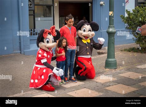 Mickey and Minnie Mouse pose with two children in Plaza de la Cultura ...