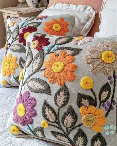 Two Decorative Pillows On A Bed With White Linens And Colorful