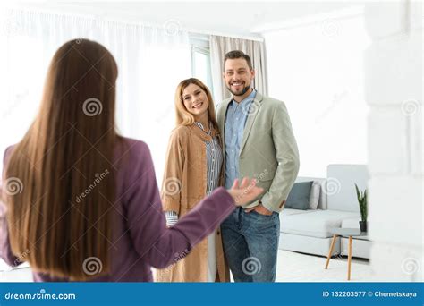 Female Real Estate Agent Showing New House To Couple Stock Image