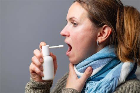 Premium Photo A Woman With A Sore Throat Sprays Medicine Aerosol