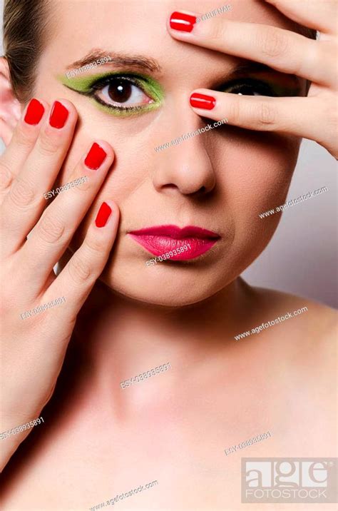Fashion Glamour Portrait Of A Blonde Woman With Heavy Makeup Holding Fingers In Front Of Her Eye