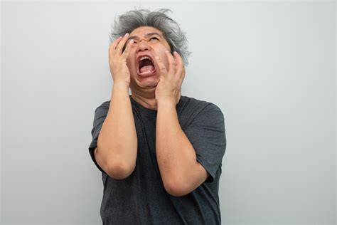 Portrait Of A Furious Senior Grey Haired Man Yelling And Screaming And