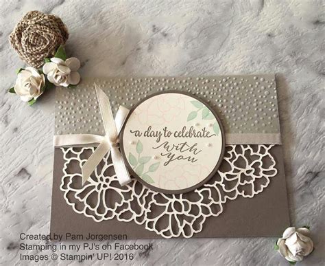 A Close Up Of A Card On A Table With Flowers And Paper Doily Around It