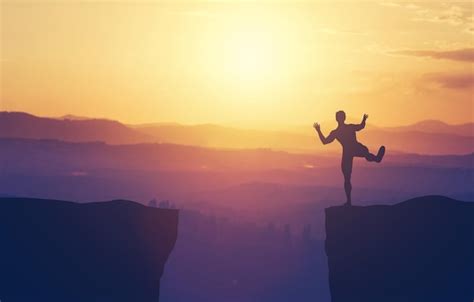premium photo man balancing   edge   cliff
