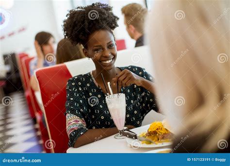 Multiracial Female Friends Eating Fast Food At A Table In The Diner