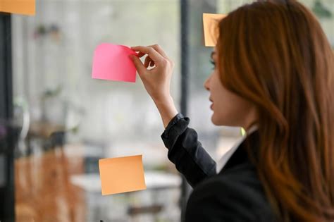 Premium Photo A Female Marketing Assistant Looking At The Sticky Note