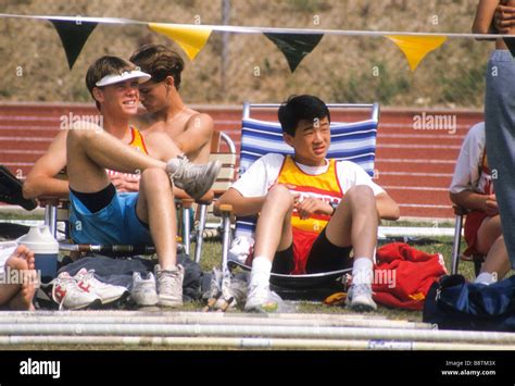 Asian-American teen boy and friend rest between track meet events Stock ...