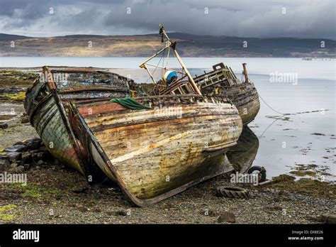 Derelict Fishing Boats Rest On The Shore At Low Tide On The Isle Of