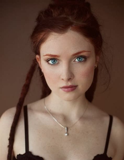 A Woman With Blue Eyes Wearing A Black Bra And Braided Hair Is Looking