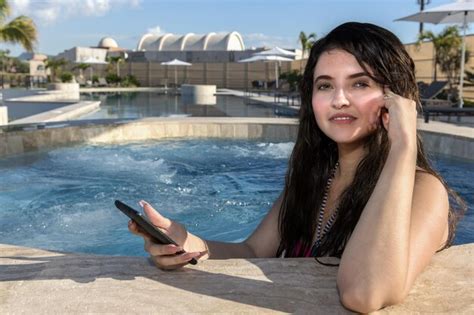 Chica latina mexicana en el jacuzzi con un teléfono celular Foto Premium