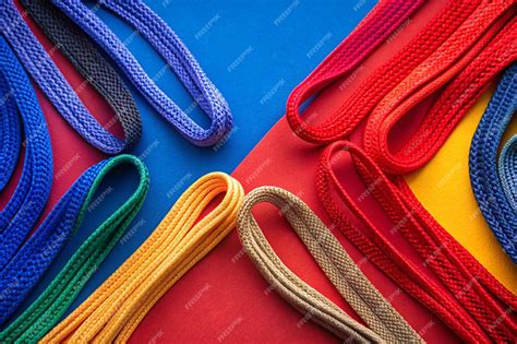 From above of arrange colored shoelaces on red and blue background ...