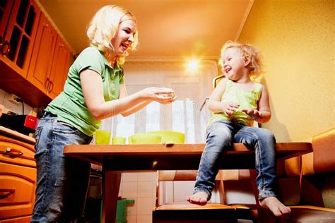 Mother And Her Three Years Old Blonde Daughter Are Cooking In A Kitchen Happy Mom And Small