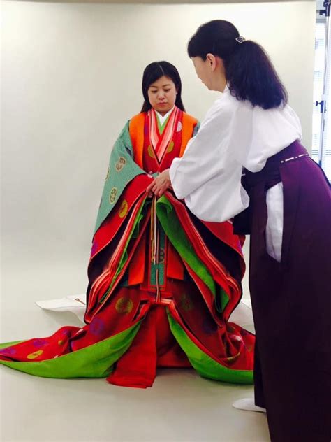 A Woman Being Dressed In Junihitoe Japanese Traditional Clothing