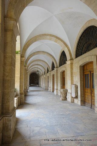 An Arched Hallway With Stone Floors And Arches