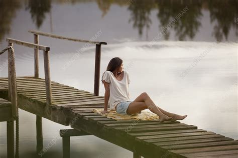 Woman Sitting On Dock Over Lake Stock Image F Science