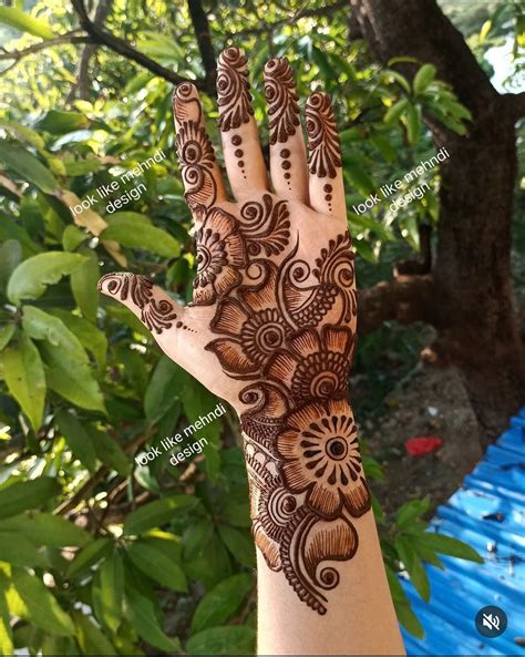 A Hand With Henna On It And Some Trees In The Backgrouf