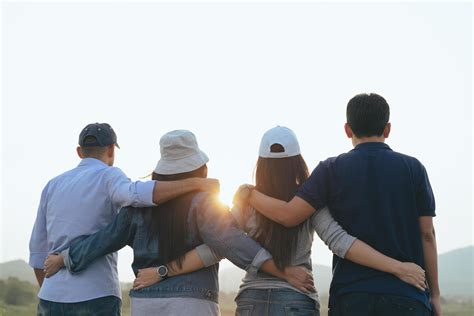 Closeup of male and female friends hugging each other looking at the
