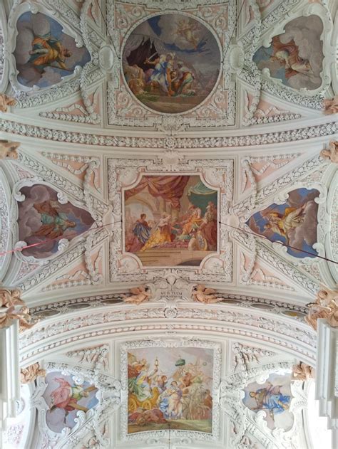 An Ornate Ceiling With Paintings On It In A Room Filled With White And