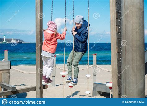 Enfants Heureux Jouant Au Terrain De Jeu Sur Une Plage Image Stock