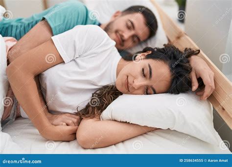 Young Hispanic Couple Lying On Bed Sleeping At Bedroom Stock Image