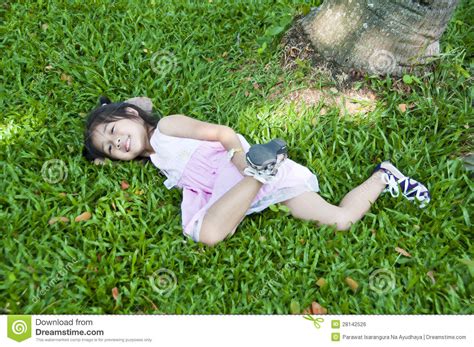 Petite Fille Asiatique Se Trouvant Sur L Herbe Verte Photo Stock