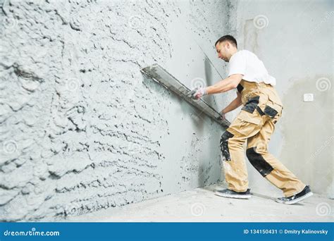 Plasterer Using Screeder Smoothing Putty Plaster Mortar On Wall Stock