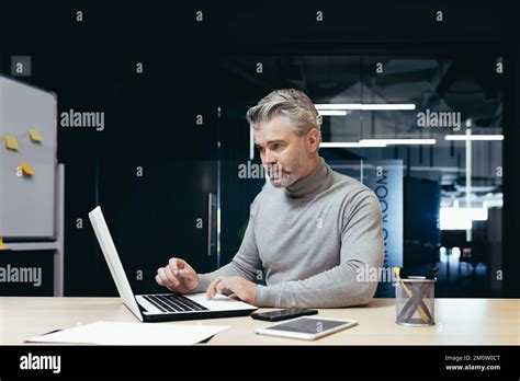 Serious And Pensive Mature Investor Working Inside Modern Office Senior Gray Haired Businessman