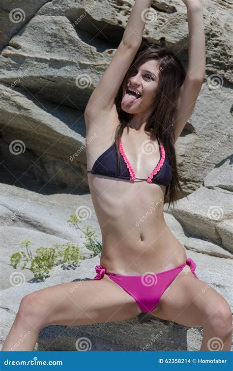 Slim Female In Bikini Sitting On Sea Rocks Stock Photo Image Of