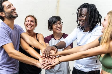 Grupo De J Venes De Diferentes Etnias Sonriendo Y Juntando Sus Manos